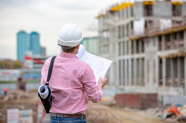 Portrait d'architecte au travail avec casque dans un chantier de construction