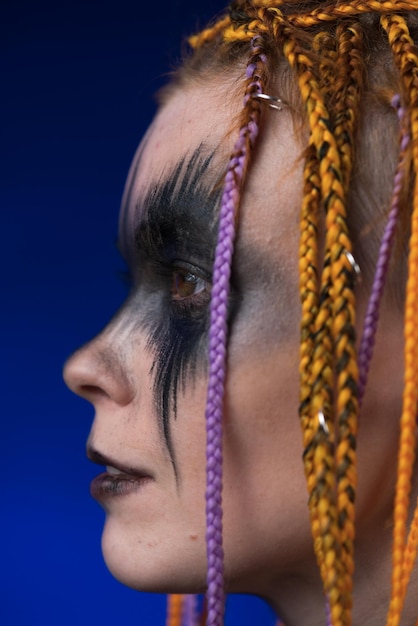Portrait artistique d'une femme avec un maquillage de scène noir d'horreur peint sur le visage et une coiffure de dreadlocks