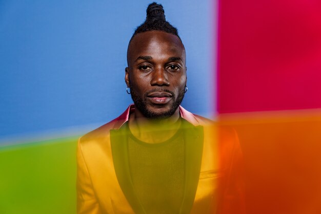 Portrait artistique avec lumières gel. Bel homme posant sur des fonds colorés