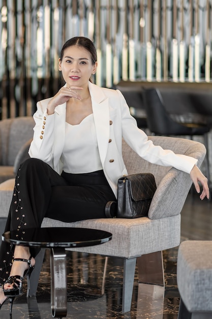 Portrait Asian businesswoman wearing costume formel assis sur le canapé dans le hall moderne