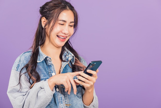 Portrait, de, asiatique, beau, jeune femme, confiant, porter, denim, jean, chemise, tenir, smartphone, dactylographie, smartphone