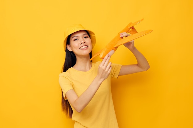 Portrait asiatique belle jeune femme avec un avion jaune dans ses mains un jouet tir monochrome