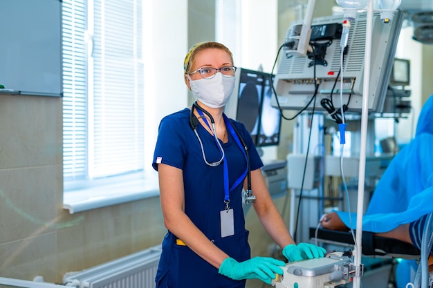 Portrait de l'assistante médicale infirmière professionnelle en masque chirurgical pendant l'opération Salle d'opération de l'hôpital moderne