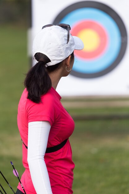 Portrait d'athlète féminine pratiquant le tir à l'arc dans le stade.