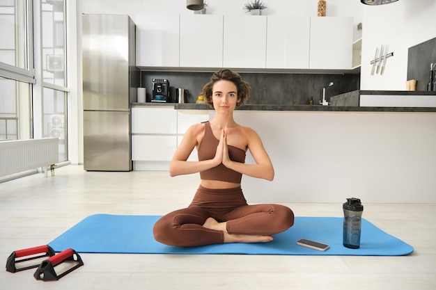 Portrait d'une athlète féminine pratiquant le yoga méditant dans la pose de lotus en utilisant la technique de pleine conscience w