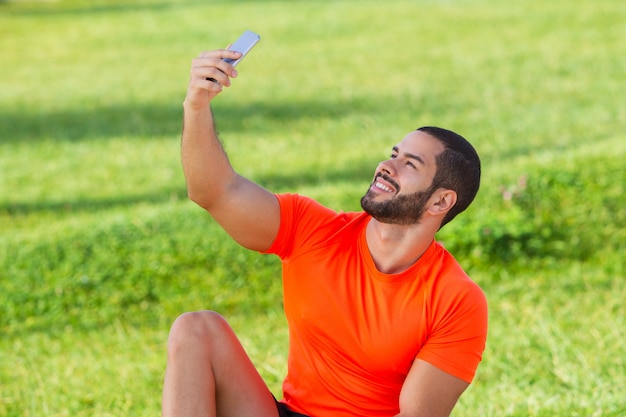 Portrait de l&#39;athlète heureux prenant selfie dans le parc