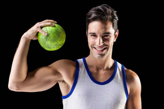 Portrait d'athlète masculin heureux tenant une balle