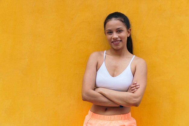 Portrait d'un athlète regardant la caméra devant un mur jaune.