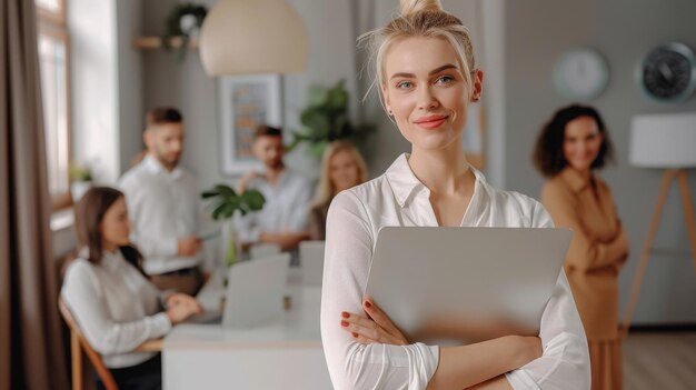 Portrait d'une attrayante femme entrepreneur en vêtements décontractés tenant un ordinateur portable à la main debout dans un bureau