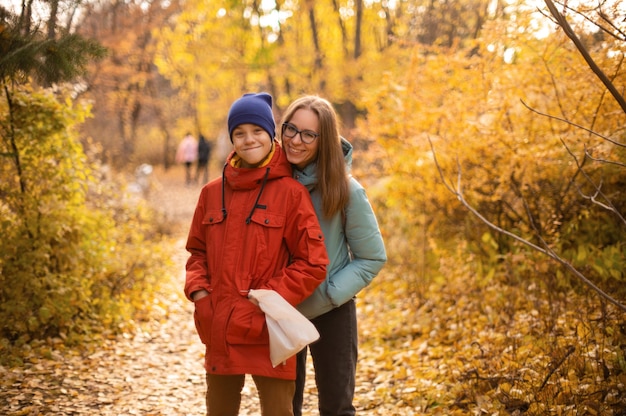 Portrait d'automne d'une belle femme heureuse avec son fils