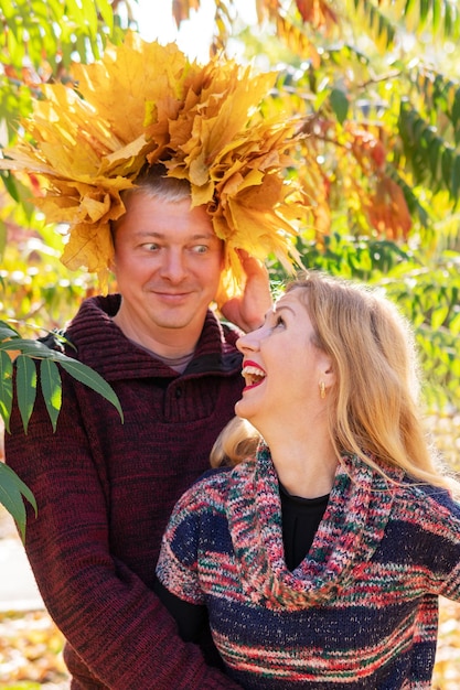 Portrait d'automne drôle de mari avec une couronne de feuilles et une femme qui rit