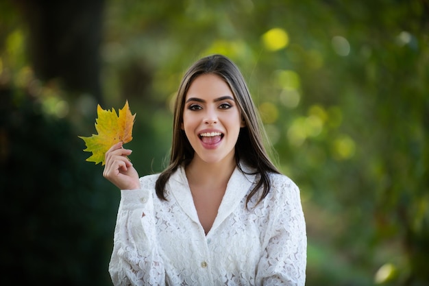 Portrait d'automne d'une femme joyeuse avec des feuilles d'érable jaunes portrait d'une fille de beauté avec des feuilles d'automne