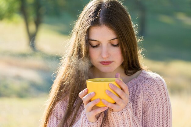 Portrait d'automne d'une fille avec une tasse jaune