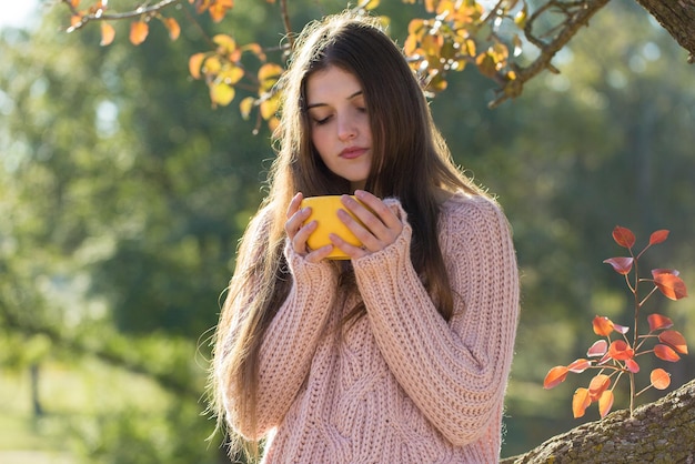 Portrait d'automne d'une fille avec une tasse jaune