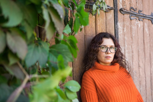 Portrait d'automne d'une jolie jeune femme à lunettes élégantes dans un swea orange à la mode tricoté