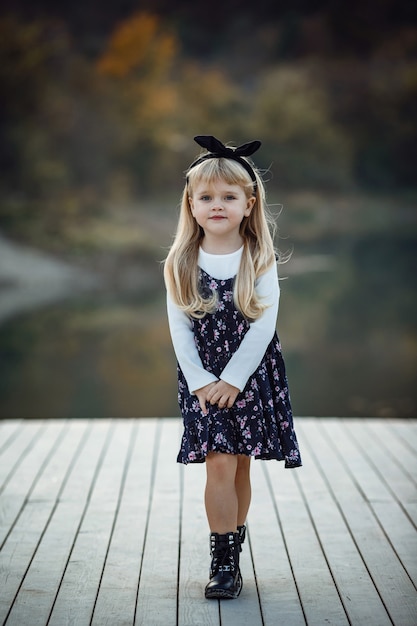 Portrait d'automne en plein air d'une fille avec un chapeau et des jeans. Fond de nature, paysage rural, style campagnard près d'un lac dans la forêt