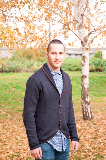 Portrait d&#39;automne. Portrait d&#39;un beau jeune homme dans le parc couvert de feuilles mortes