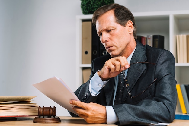 Photo portrait d'un avocat mature professionnel lisant un document dans la salle d'audience