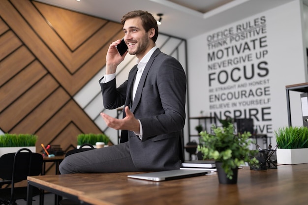 Portrait d'un avocat prospère parlant au téléphone au bureau