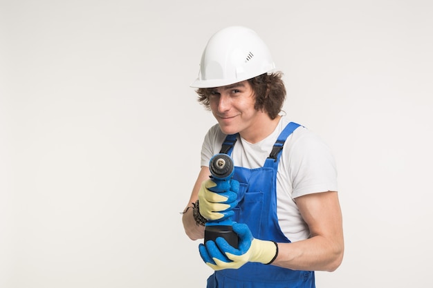 Portrait de beau constructeur heureux avec skrewdriver pointé sur la caméra