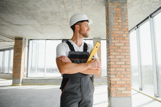 Portrait d'un beau constructeur masculin en salopette et casque