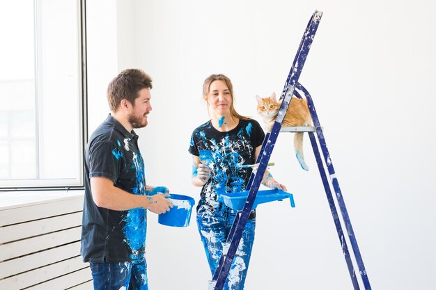 Portrait de beau couple drôle avec chat faisant redécoration