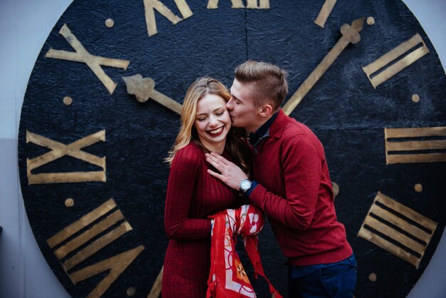 Portrait de beau couple élégant debout près de l'horloge.