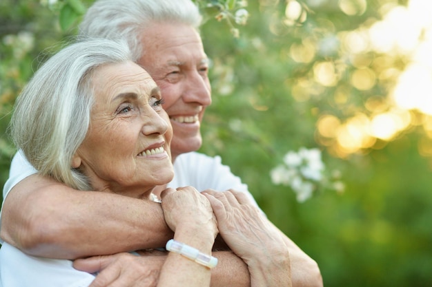 Portrait d'un beau couple de personnes âgées étreignant dans le parc