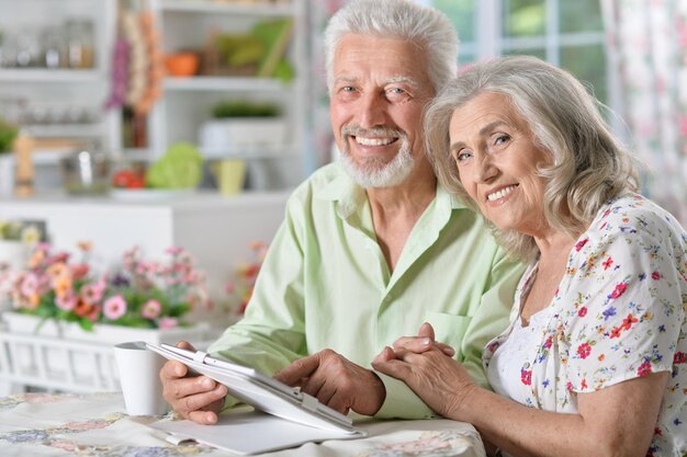 Portrait d'un beau couple de personnes âgées heureux à l'aide d'une tablette