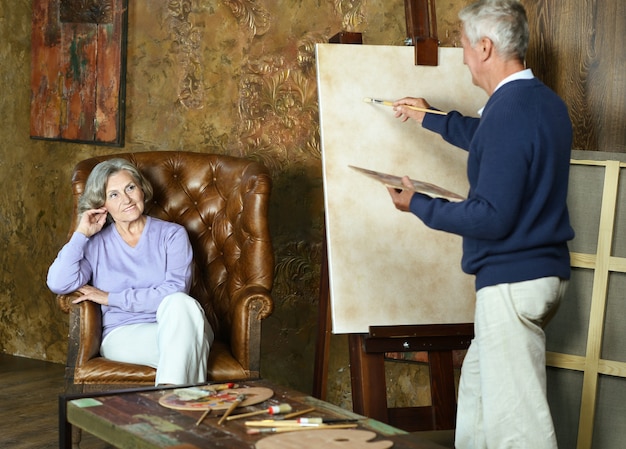 Portrait de beau couple de personnes âgées peignant avec chevalet