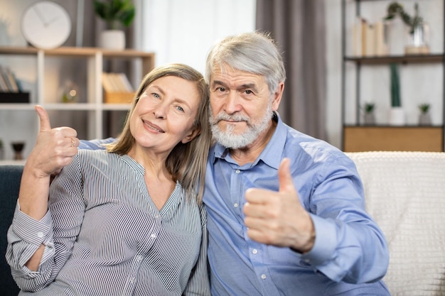 Portrait d'un beau couple de personnes âgées reposant sur un canapé à la maison