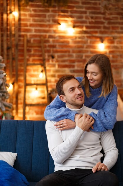 Portrait de beau couple souriant étreignant à Noël