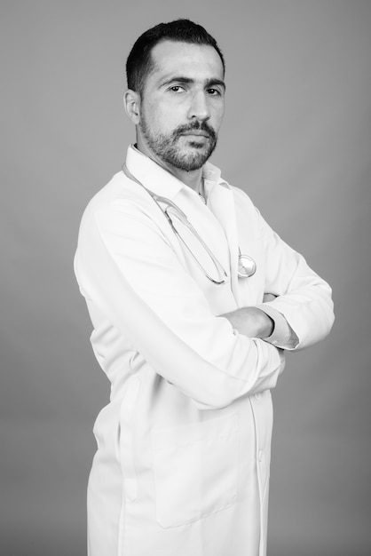 Portrait de beau docteur persan barbu sur gris en noir et blanc