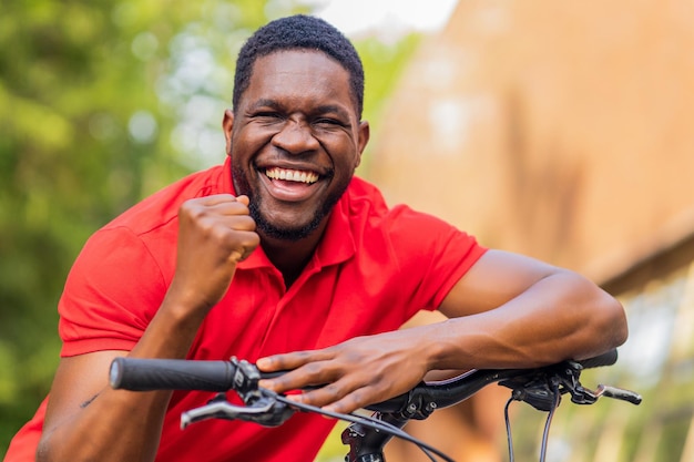 Portrait de beau hipster élégant souriant avec vélo dans le parc