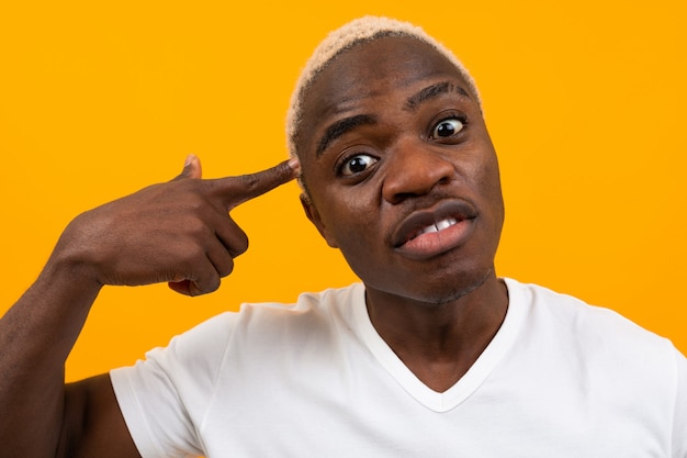 Portrait d'un beau homme africain noir blond close-up sur fond orange