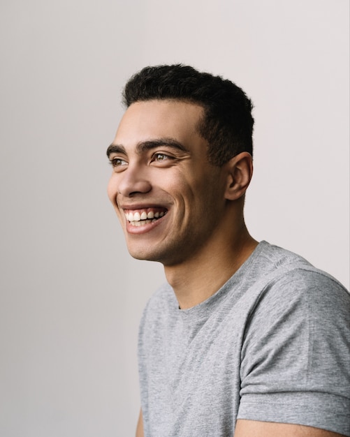 Portrait de beau homme afro-américain souriant portant un t-shirt gris décontracté, fond isolé