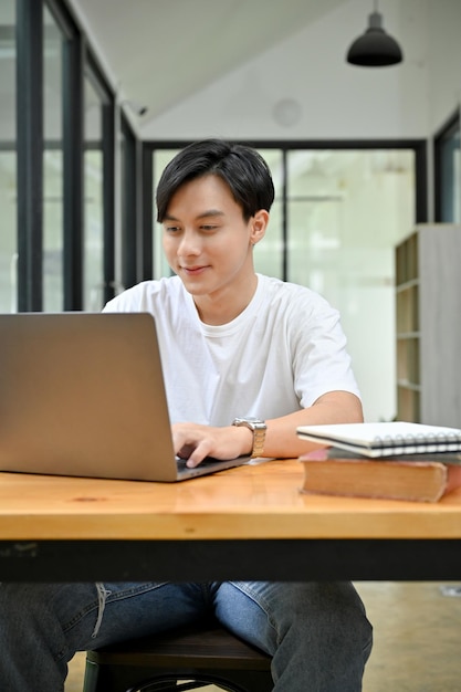 Portrait Beau et intelligent homme asiatique faisant son projet à l'aide d'un ordinateur portable