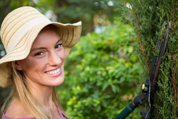 Photo portrait de beau jardinier à l'aide de taille-haies au jardin