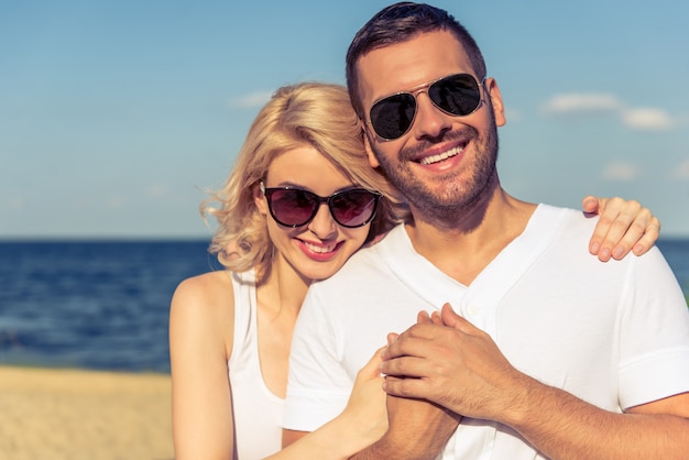 Portrait, de, beau, jeune couple, à, lunettes soleil, étreindre,