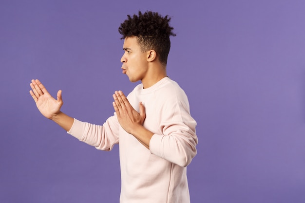 Portrait de beau jeune étudiant masculin montrant le geste.