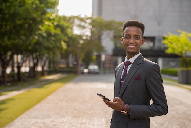 Portrait d'un beau jeune homme d'affaires africain à l'extérieur de la ville