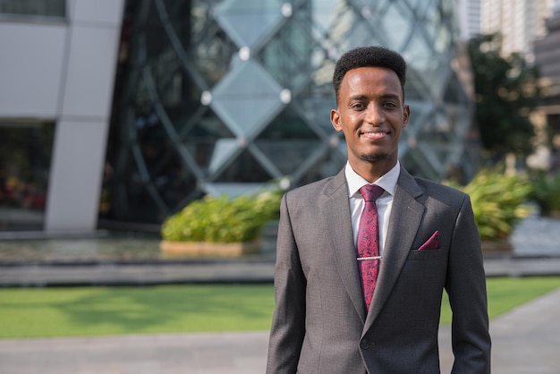 Portrait d'un beau jeune homme d'affaires africain à l'extérieur de la ville