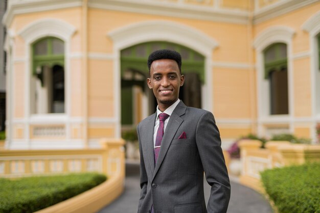 Portrait de beau jeune homme d'affaires africain à l'extérieur