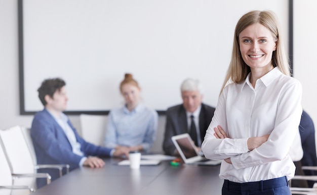 Portrait de beau jeune homme d'affaires devant son équipe au bureau