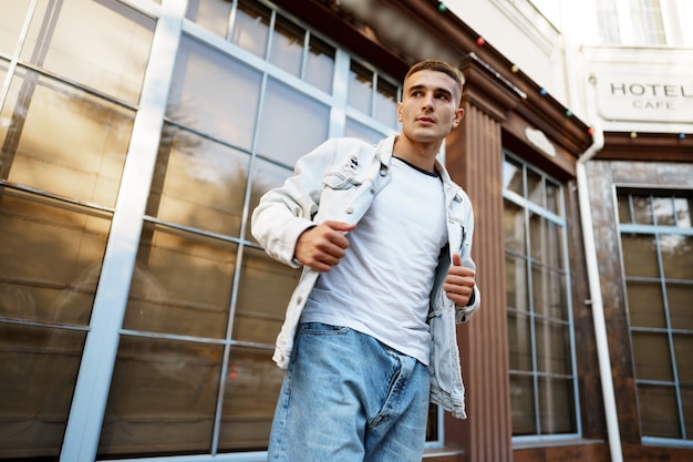 Photo portrait de beau jeune homme décontracté marchant dans la rue