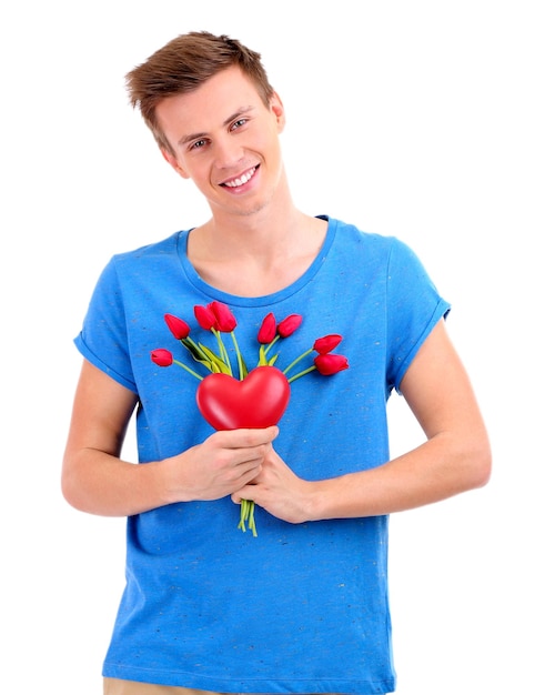 Portrait de beau jeune homme avec des fleurs et coeur décoratif, isolé sur blanc