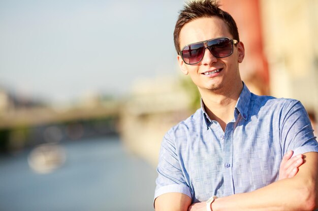 Portrait d'un beau jeune homme avec des lunettes de soleil