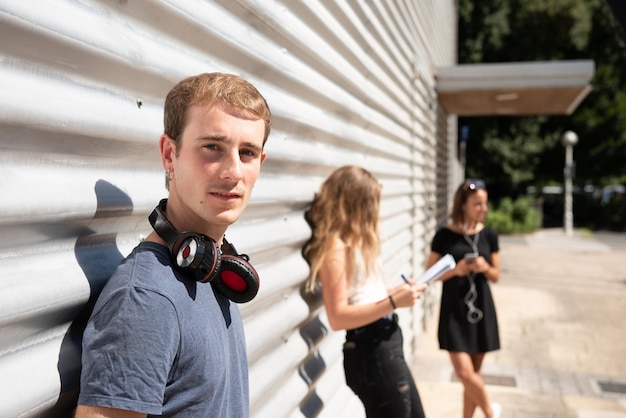 Portrait d'un beau jeune homme regardant la caméra faisant la queue dans une file d'attente