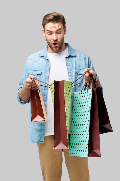 Portrait d'un beau jeune homme avec des sacs à provisions.