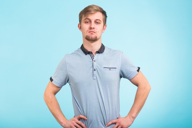 Portrait d'un beau jeune homme souriant contre bleu